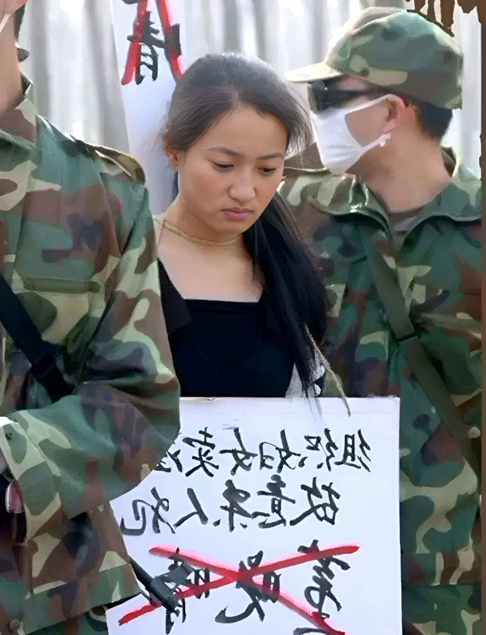 从她胸前的罪名牌上可以看出,她犯下了极其严重的罪行.