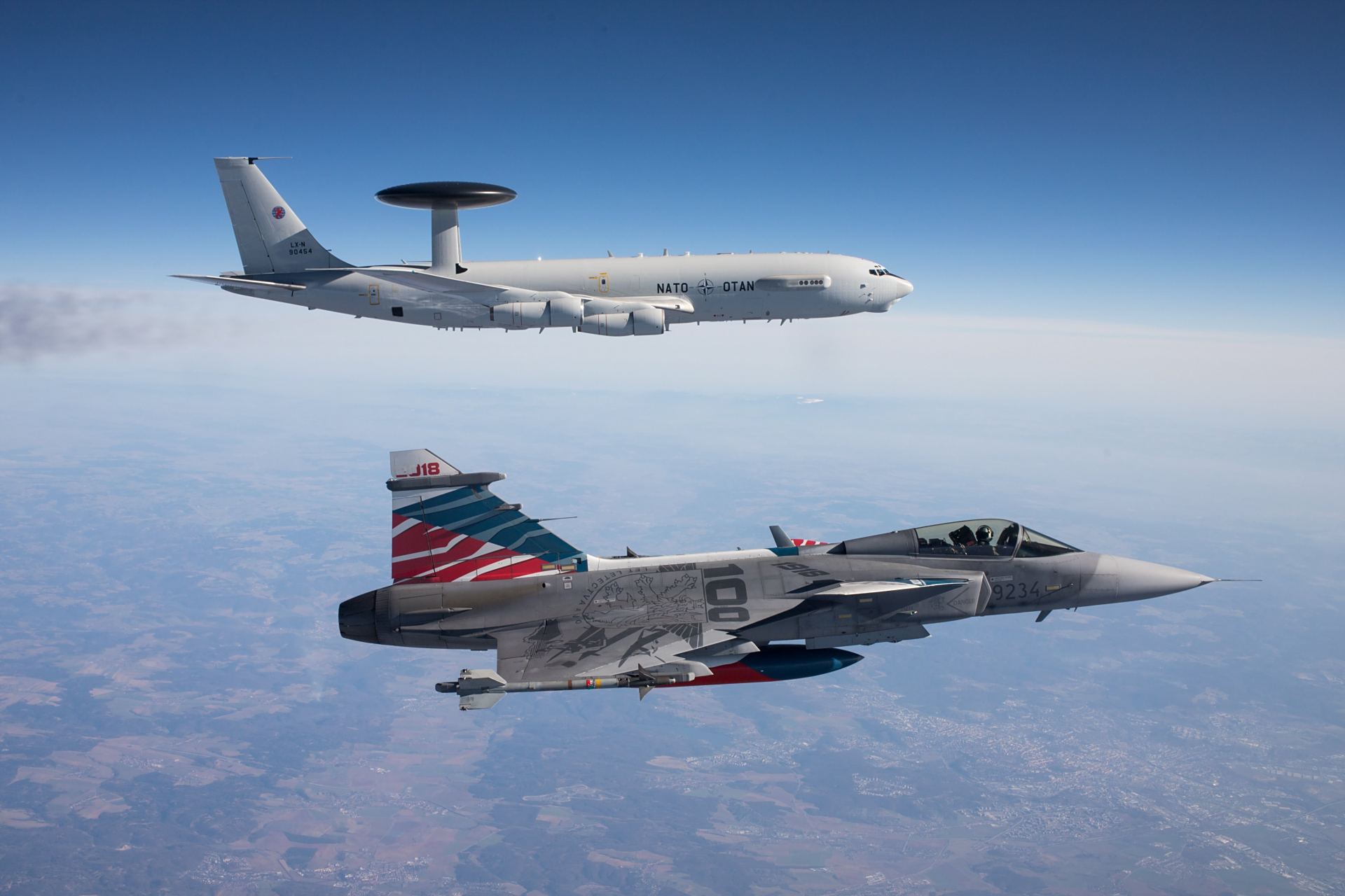 与捷克空军jas.39"鹰狮"战斗机编队飞行的北约波音e-3"望楼"预警机.