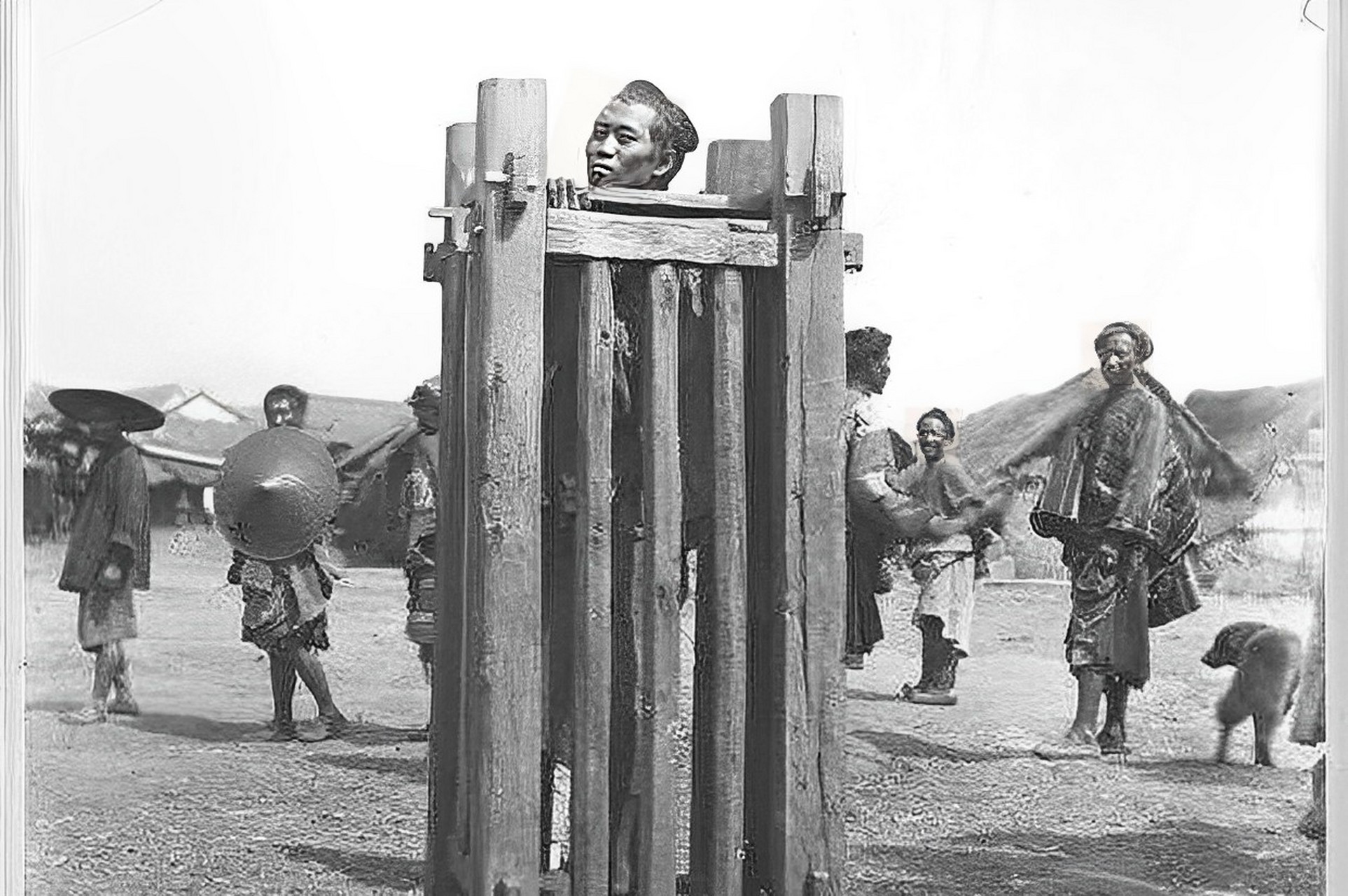 1900年,晚清老照片的一幅画面显示,一名男子被关押在衙门外的的站山笼
