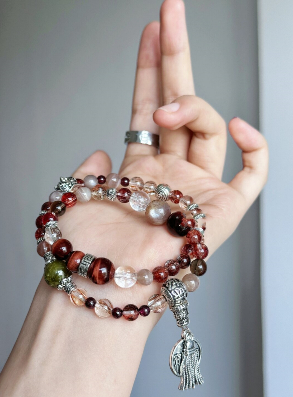 红虎眼绿石榴手串  红虎眼绿石榴手串是一种由红虎眼石和绿色石榴石