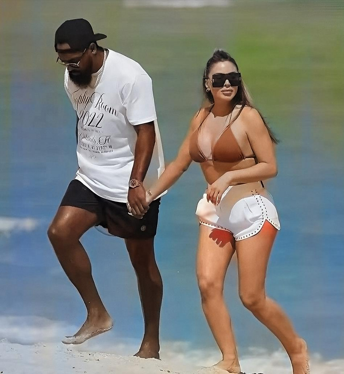 皮蓬穿着性感的比基尼,和比她小17岁的男友马库斯·乔丹在海滩上漫步