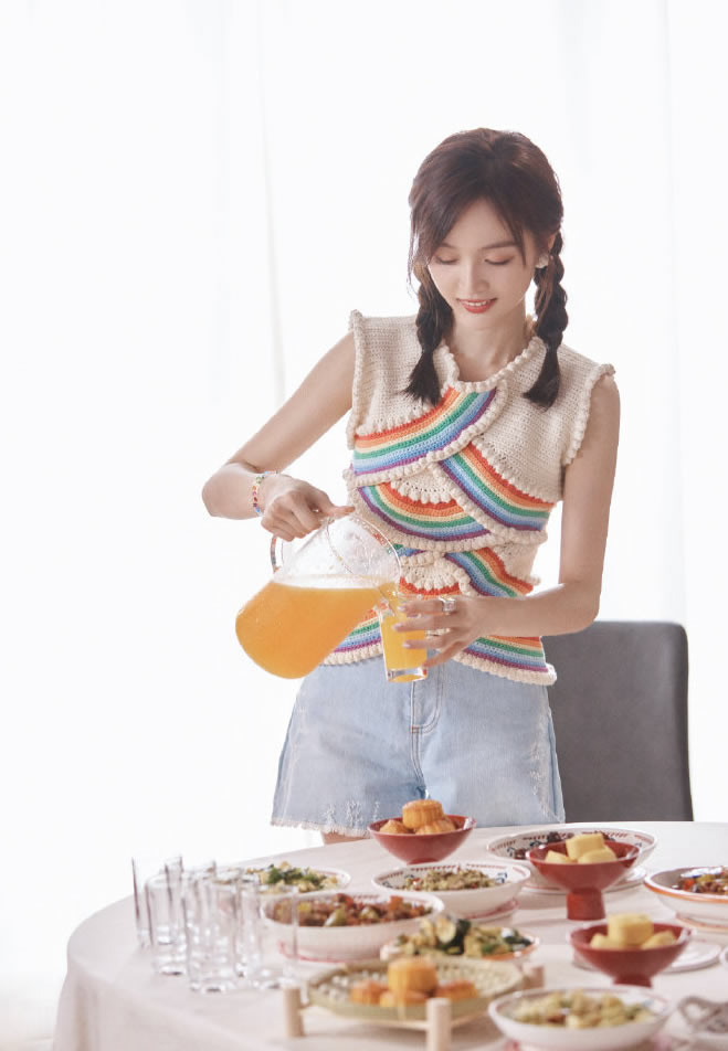 吴宣仪最新美图,她穿了一件白底彩虹色条纹针织背心,搭配一条浅蓝色的