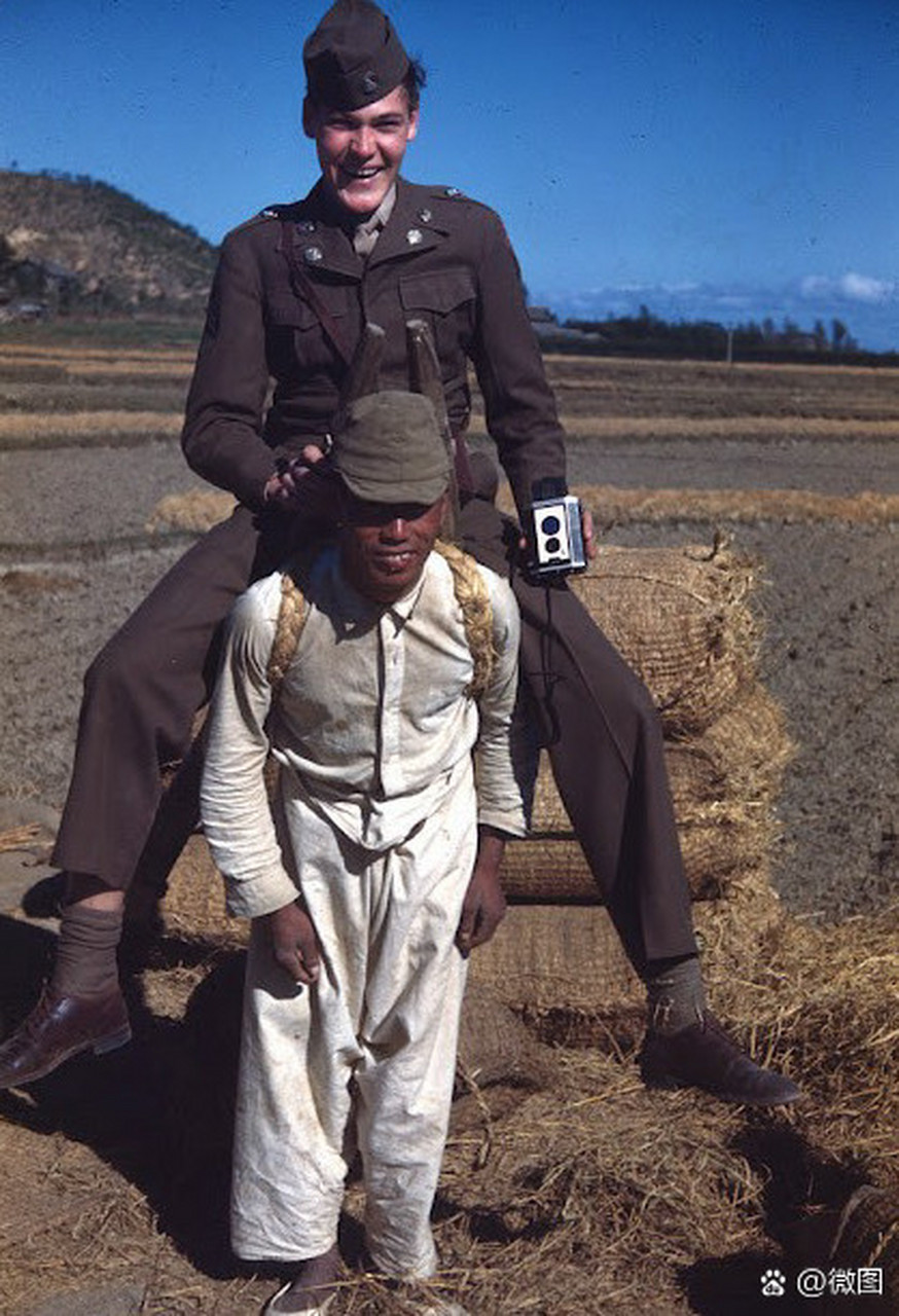下面这张照片记录了当时一名美国士兵在釜山田野间骑在韩国农民头上的