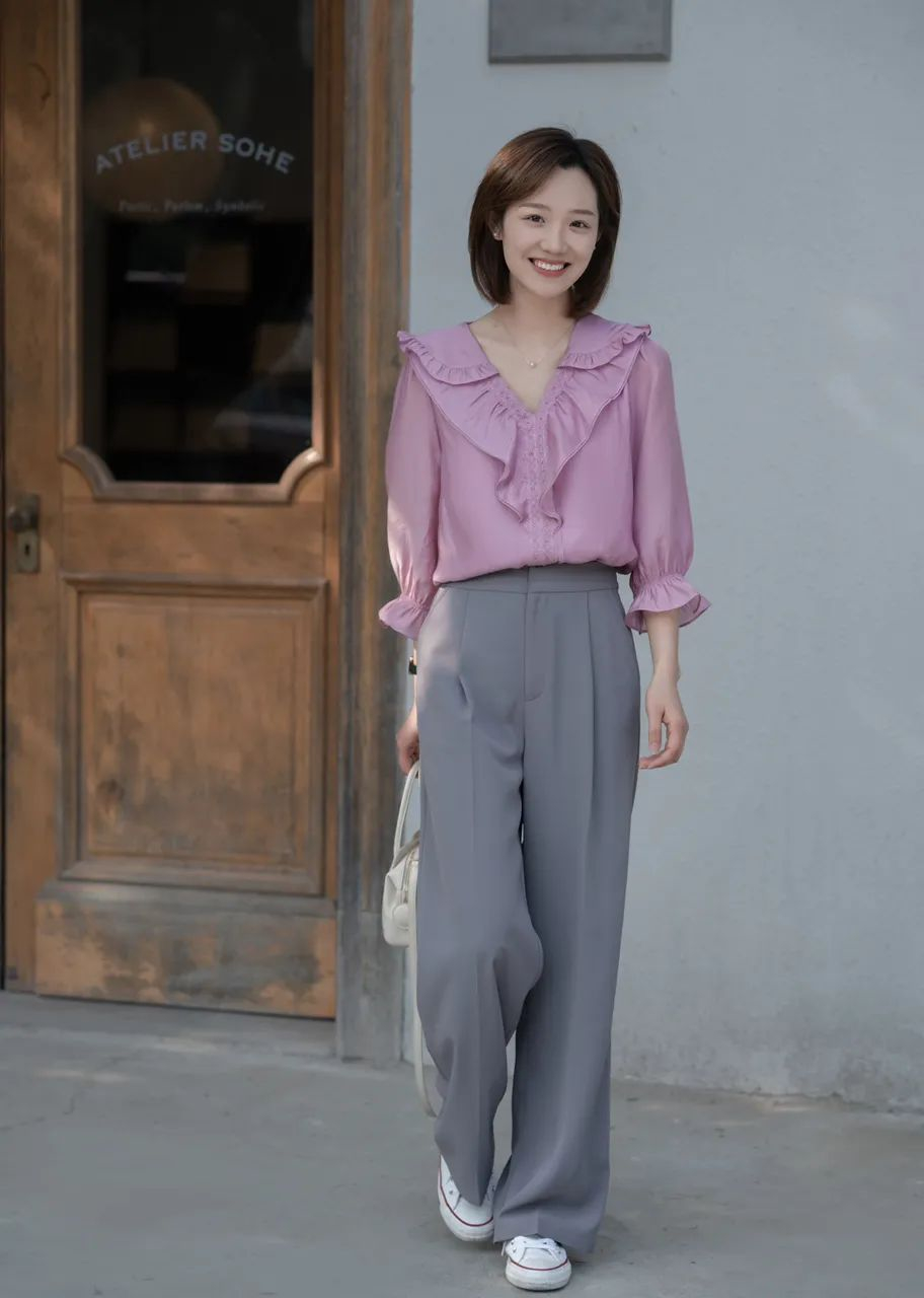 粉色上衣搭配灰色裤子  荷花边设计的上衣彰显了一份精致和细腻,与之