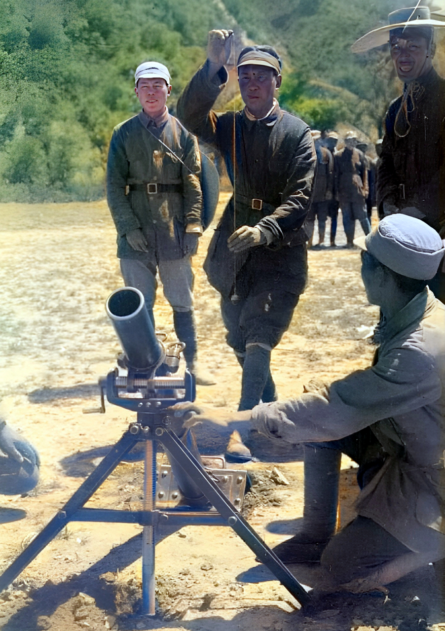 一位战士站在迫击炮的后面拿着一根底部坠着物体的线测量角度.