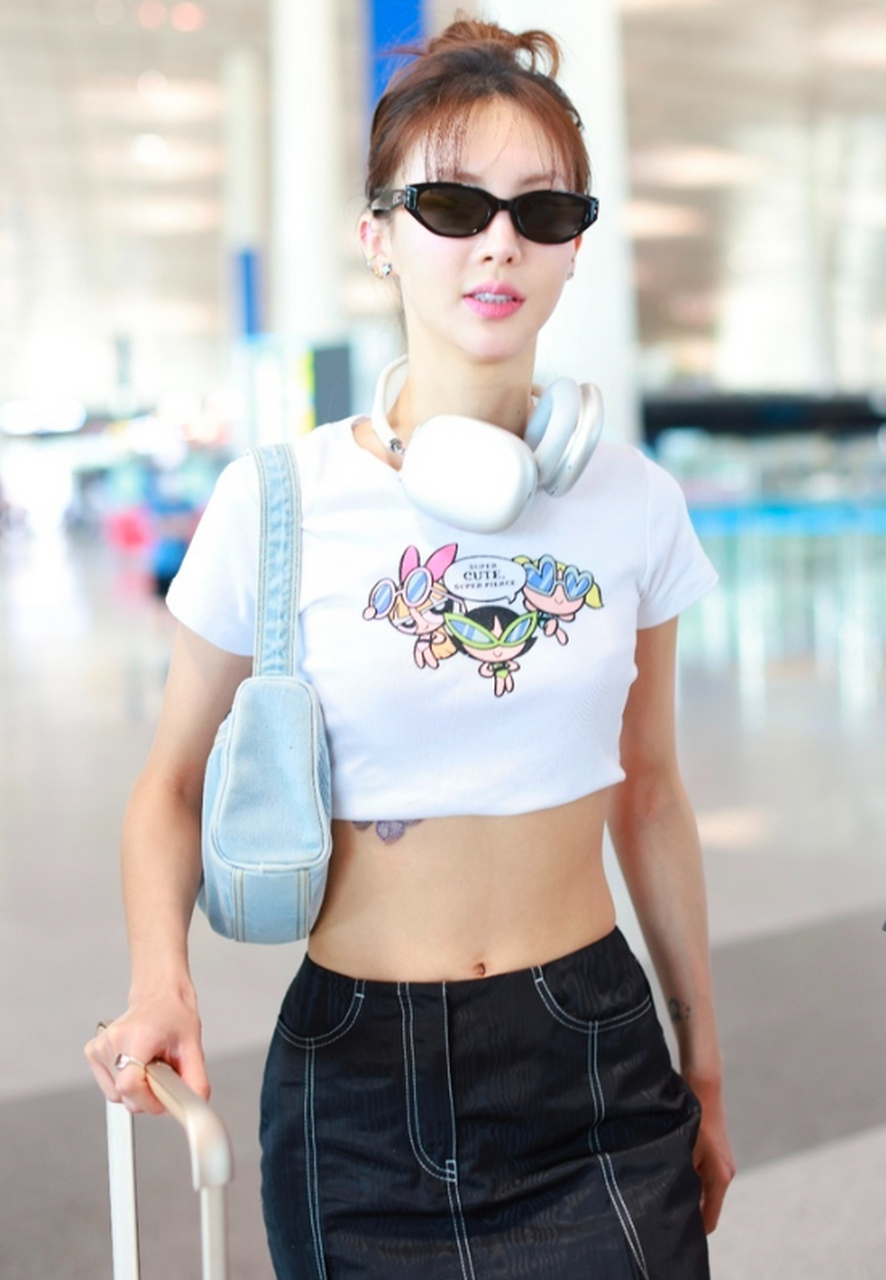 金晨戴耳机墨镜现身机场 穿露脐装大秀马甲线.