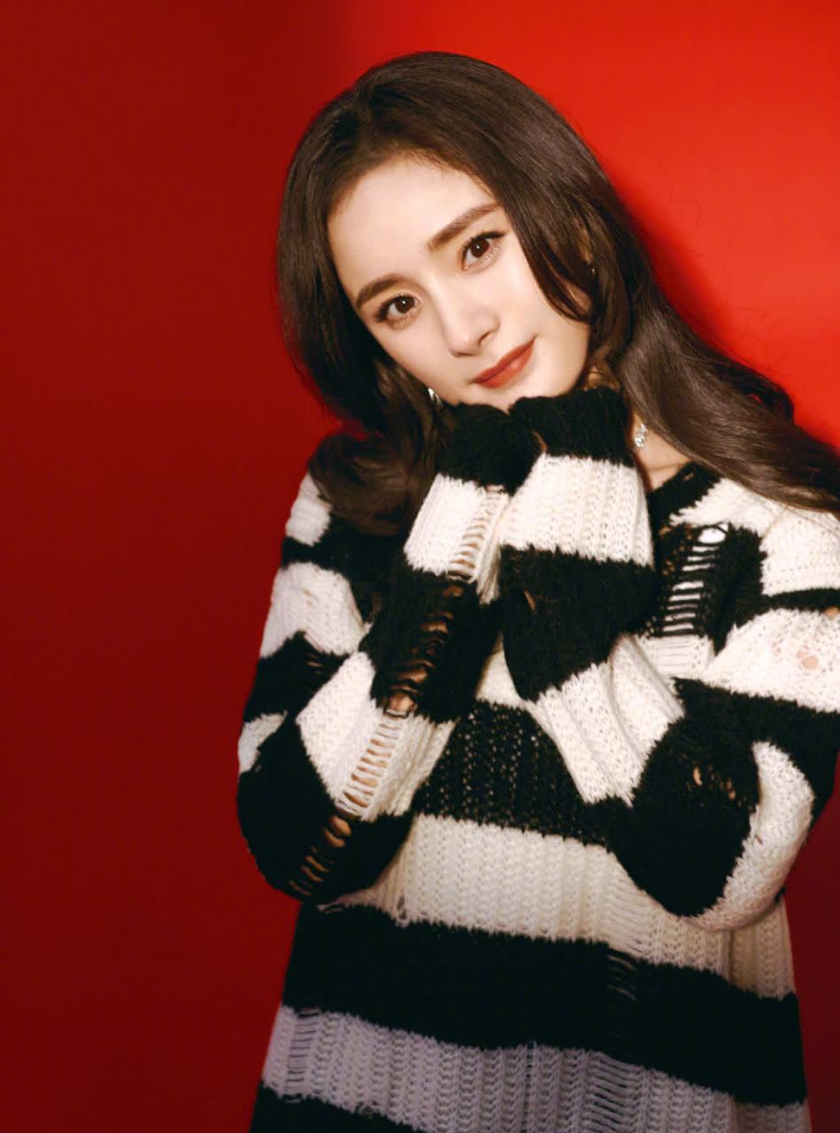 杨幂新年写真造型,身穿黑白条纹不规则破洞毛衣搭配佩斯利花纹a字裙