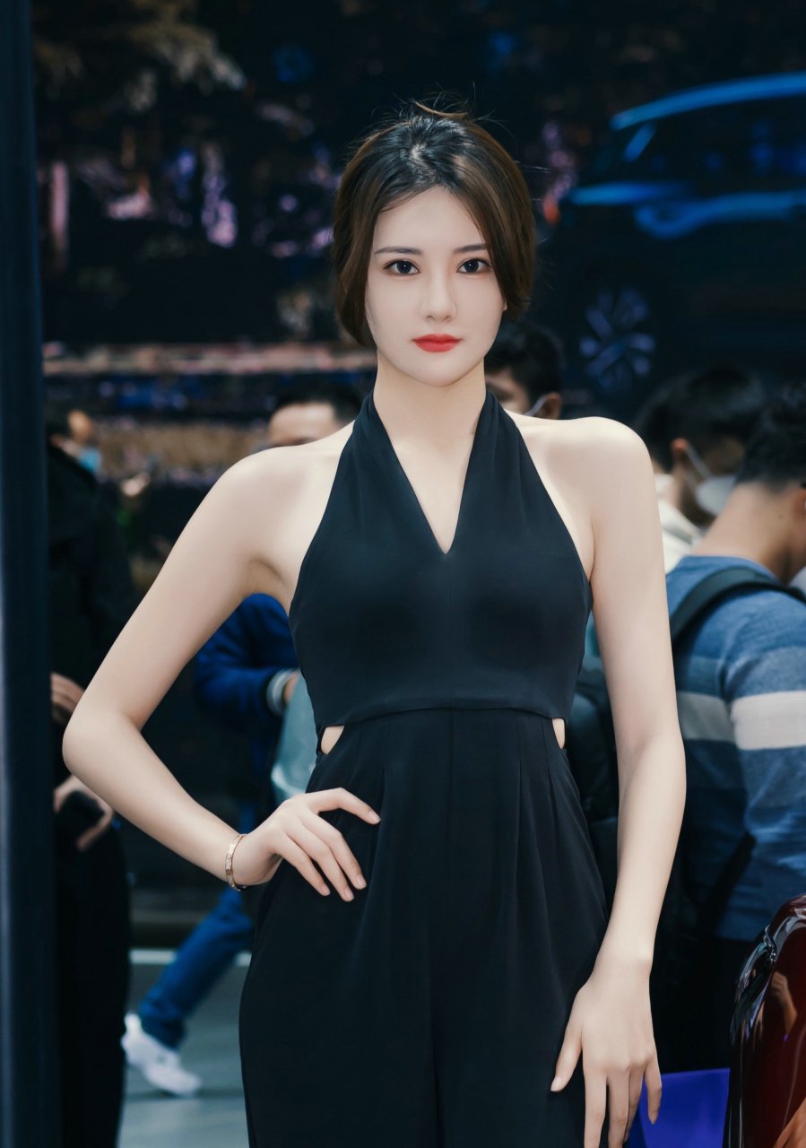 在车展上,那位漂亮的车模吸引了众人的目光.