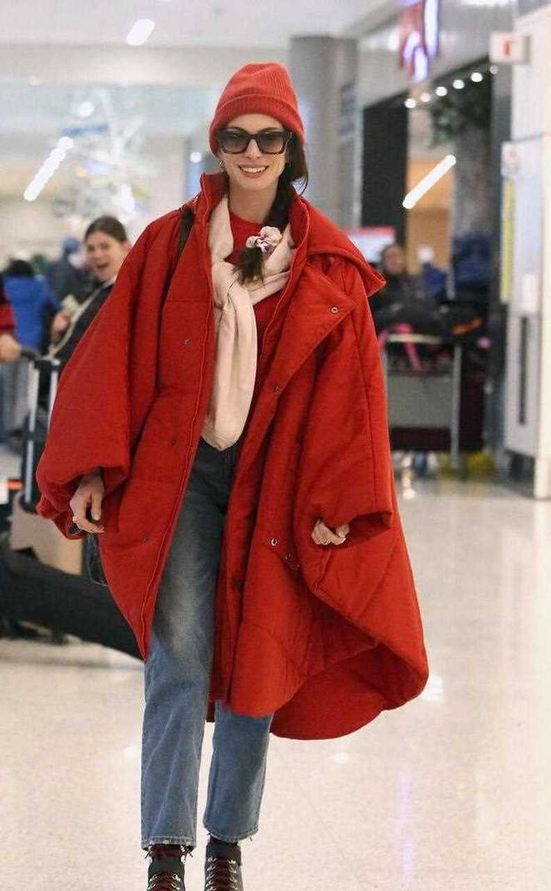 街拍来了,她戴了一顶红色的针织帽子,穿一件红色的宽松中长款羽绒服