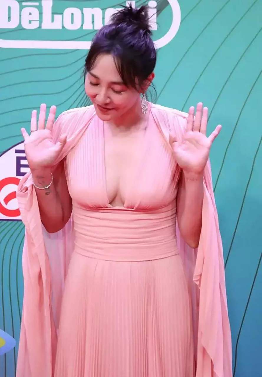 粉色礼服裙是拼接的披肩设计,展现大气时髦的层次感.