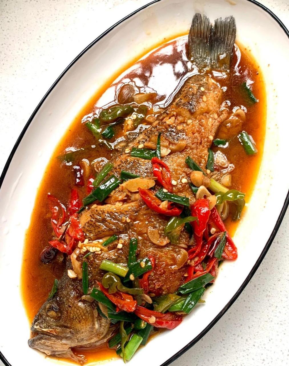 红烧鲈鱼的做法 食材:鲈鱼青红辣椒小米辣葱姜蒜 1,鲈鱼洗净,用厨房纸