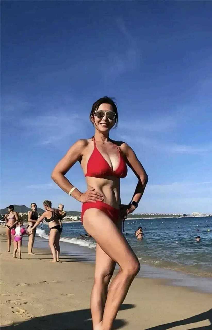 年过半百的李婉华身材管理真好,一袭红色比基尼在海边游玩,修长的双腿
