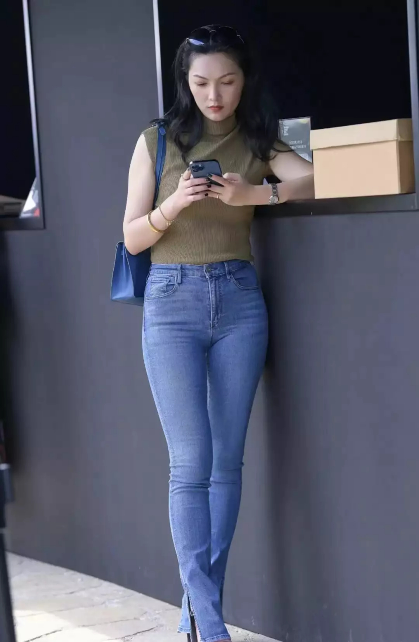 身材高挑的美女穿深蓝色牛仔裤尽显修长双腿,时尚干练又大气