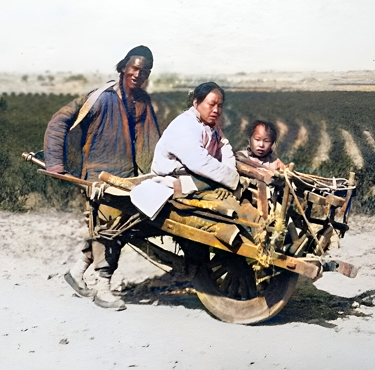 民国一位衣衫褴褛的车夫坐在墙根处等生意.