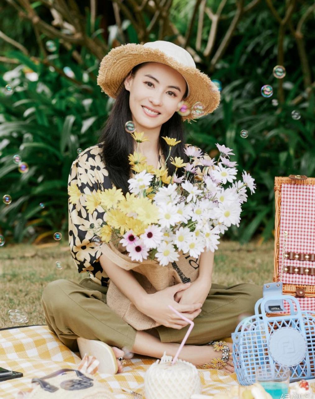 张柏芝晒春游照,春光烂漫时时适合去春游~张柏芝头戴草帽手捧雏菊笑得