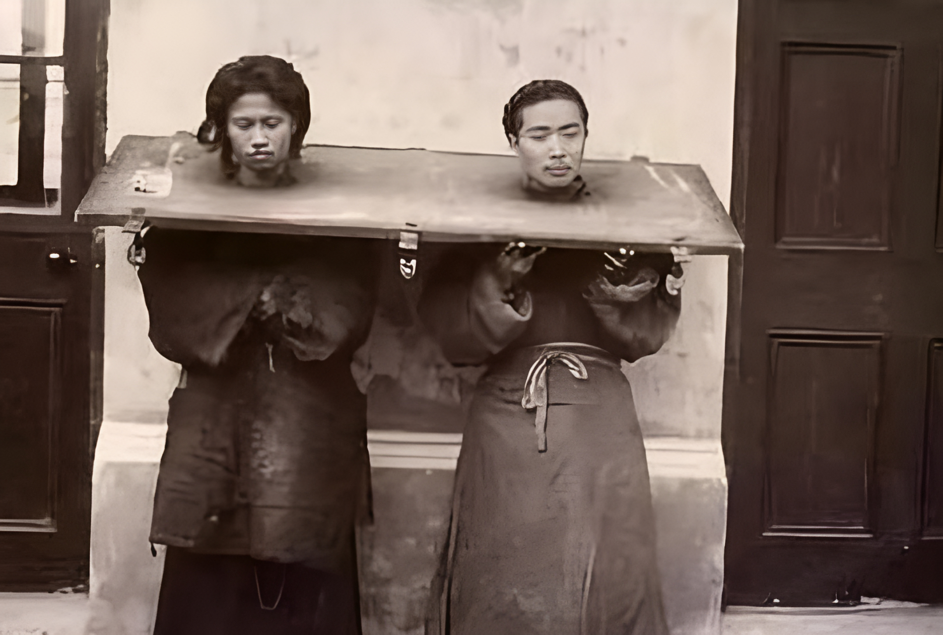 从照片中可以看出,杨乃武双手托着整个枷锁,这样可以减轻枷锁对两人