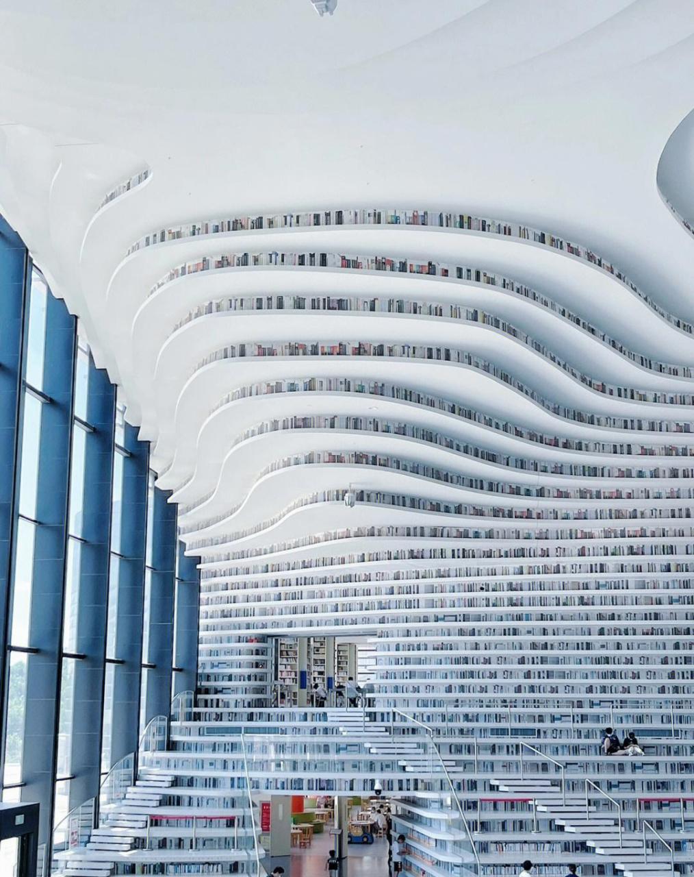 它是全中国最美图书馆——天津滨海图书馆,下边的书是真的,上面的书是