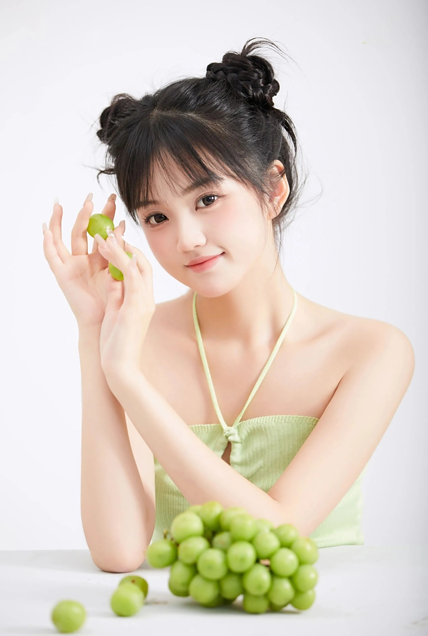 优雅的姿态中,她手持鲜绿葡萄,如艺术品般呈现.