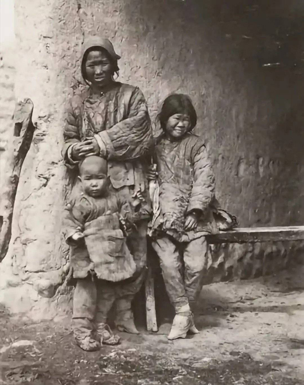 照片中的清朝妇女,都裹了小脚,穿的衣服在当时算是比较华丽.