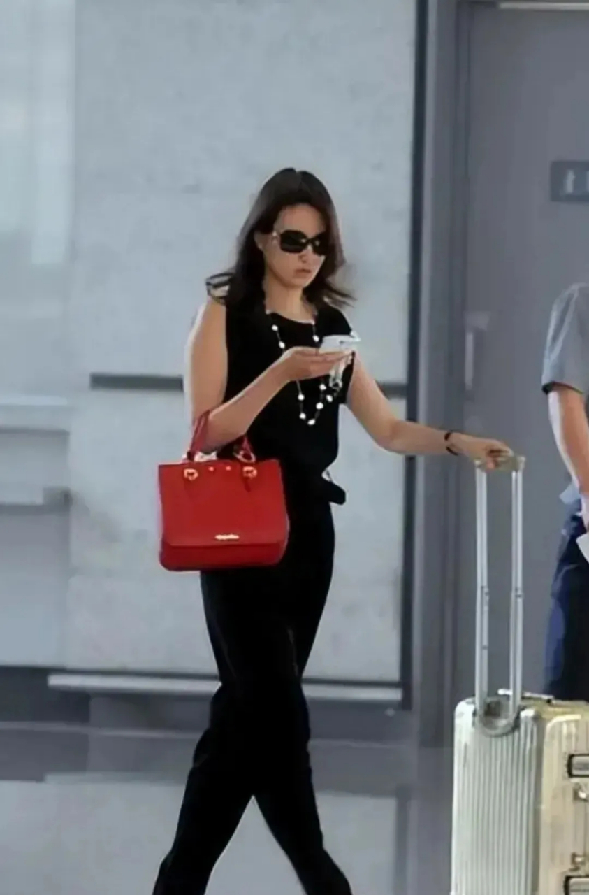 央视主持刘芳菲素颜走机场,优雅甜美,温婉知性,一袭黑色连体服,配珍珠