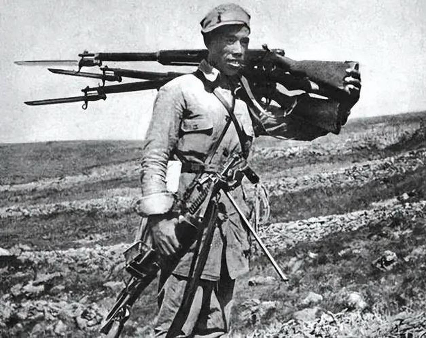 照片中这个左手肩上扛枪,右手拎着机关枪的战士叫吕俊生,他骁勇善战