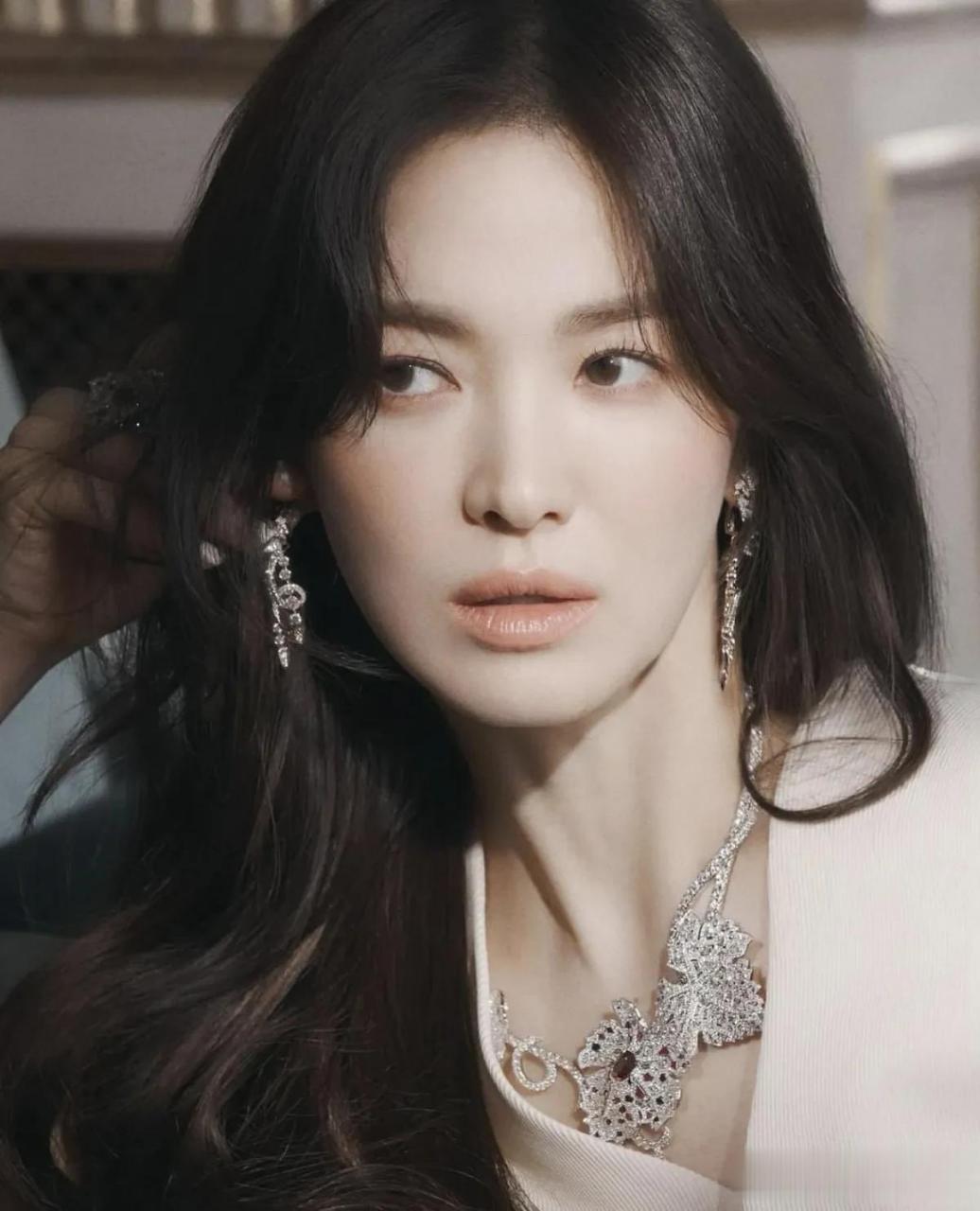 公开的照片中,宋慧乔身穿骑士皮夹克,托着下巴看着镜头.