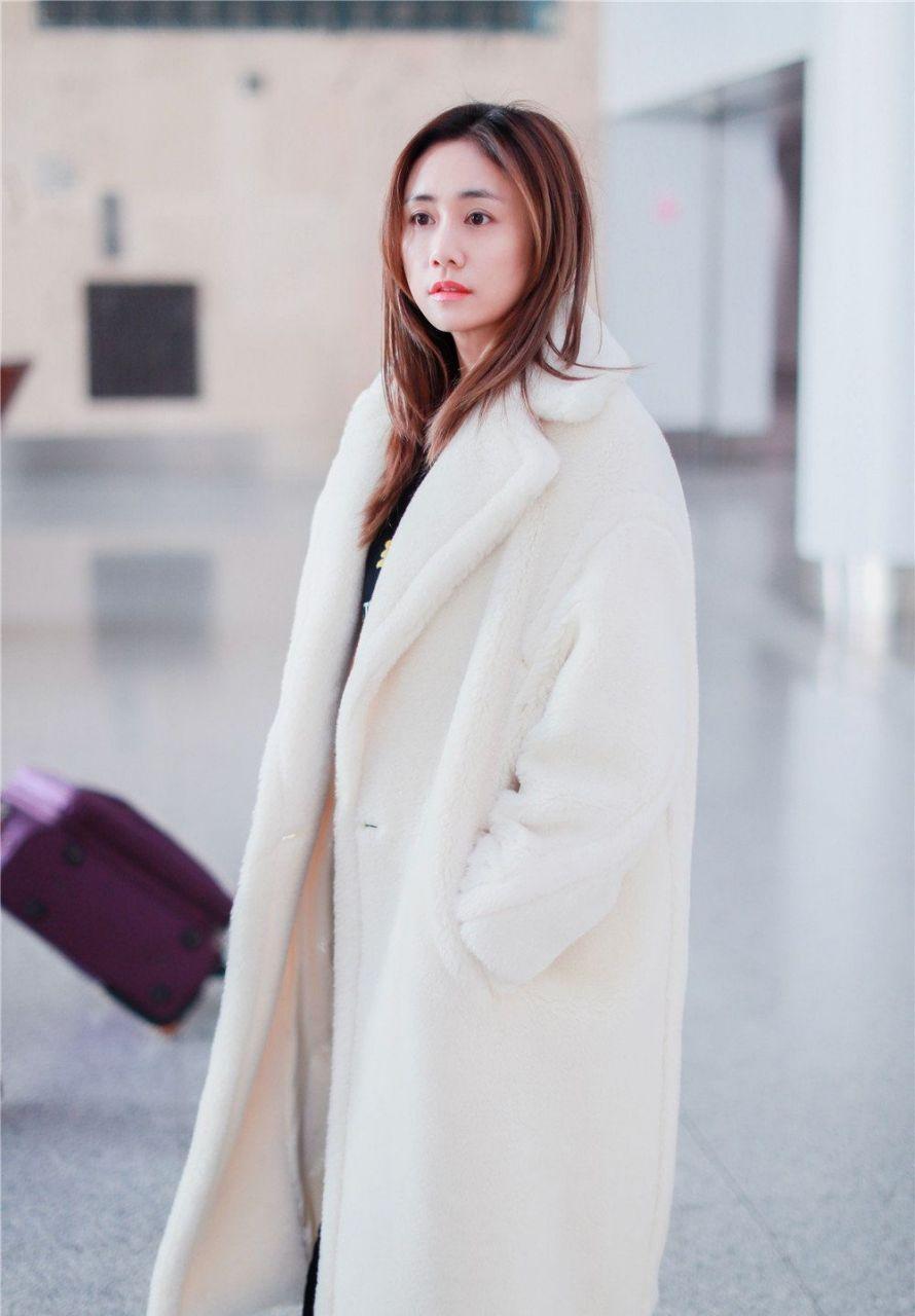 刘芸素颜现身机场,白色毛绒长款大衣搭配小白鞋,休闲又时尚,整体看