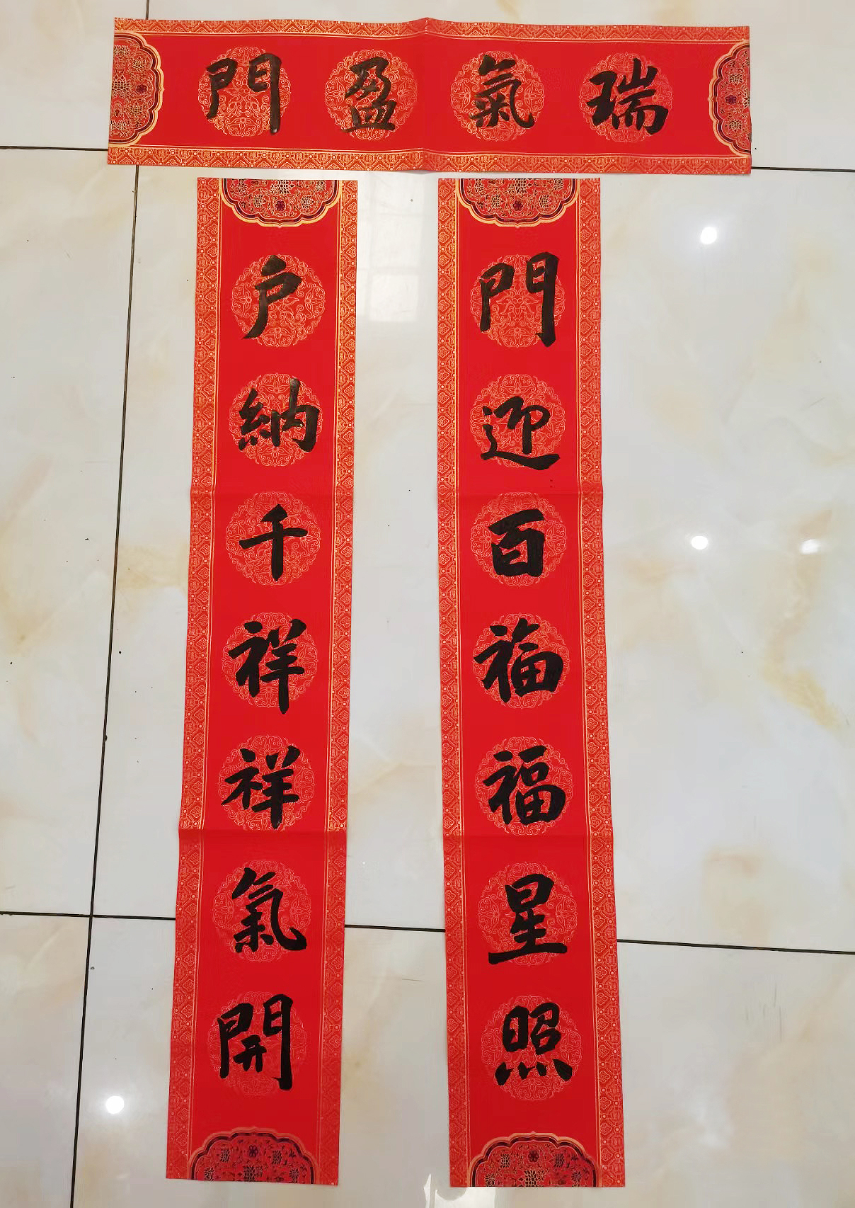 上联:门迎百福福星照  下联:户纳千祥祥气开  横批:瑞气盈门