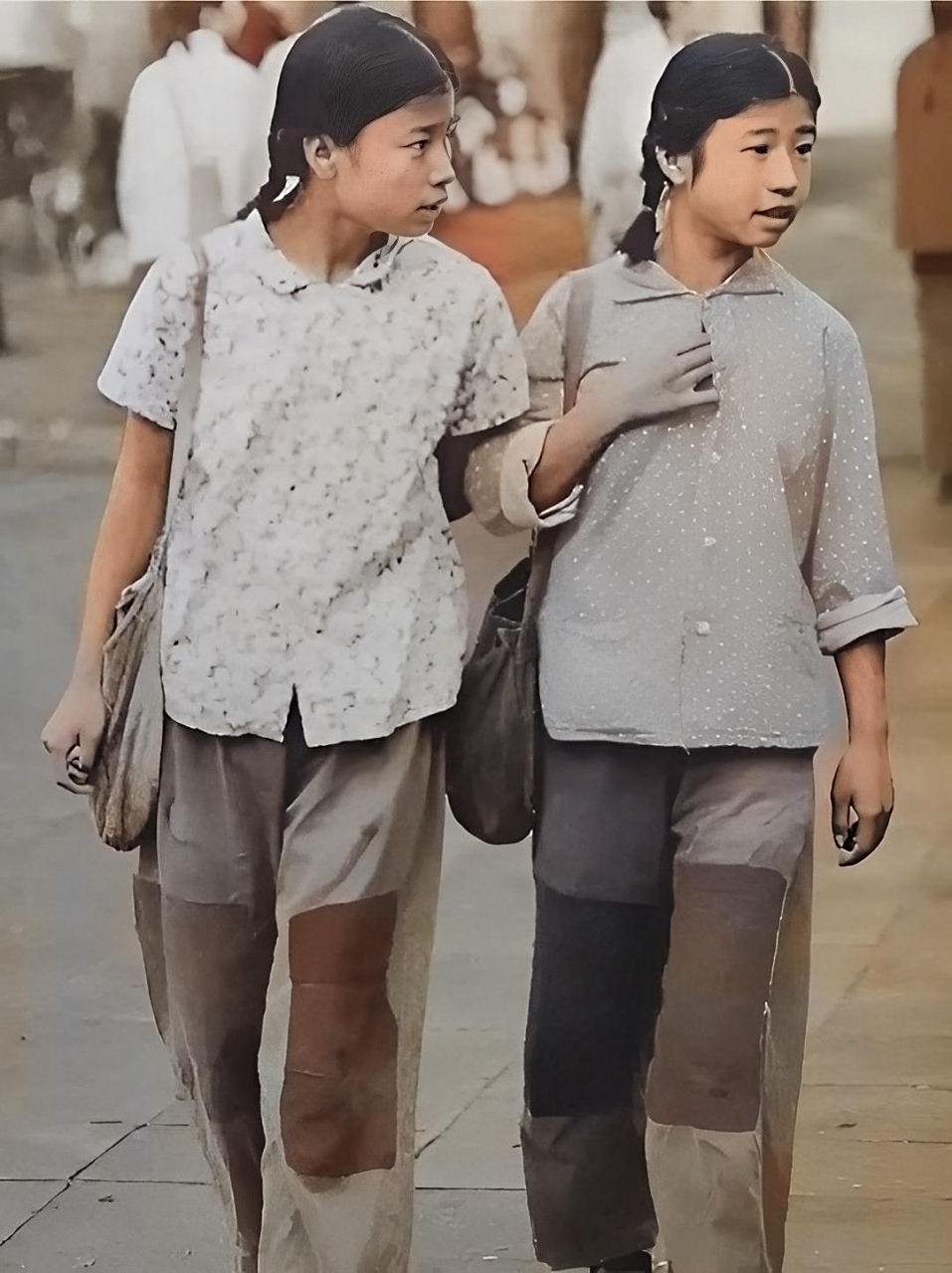 历史老照片: 20世纪60年代,两个年轻的女孩走在放学的路上,穿着朴素的