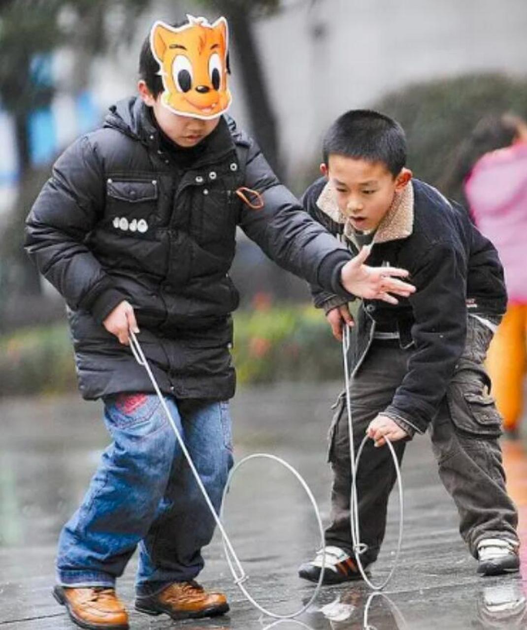 这张拍摄于30年代的照片中,两个漂亮的美国小女孩各自拿着一个滚铁圈