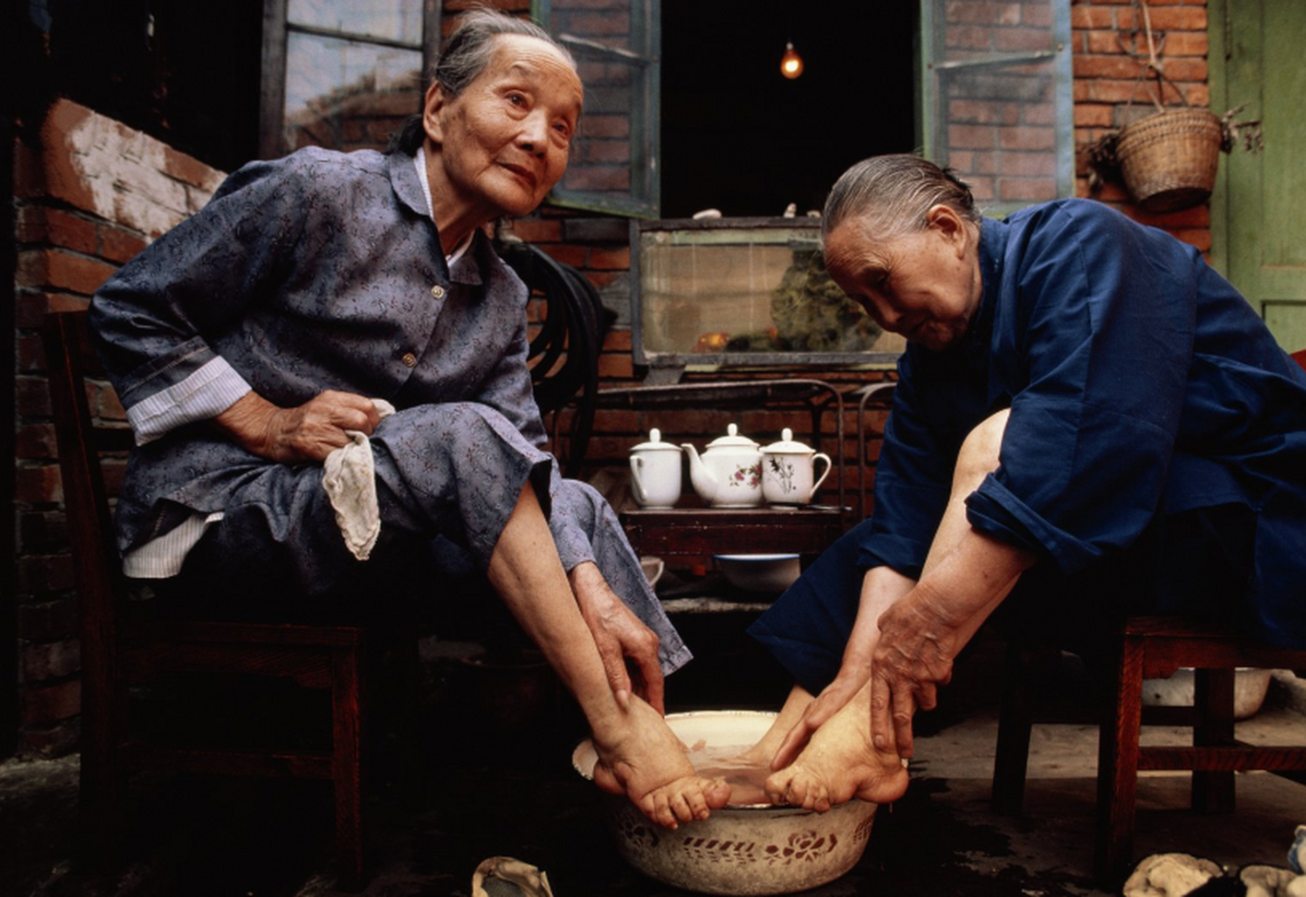 1987年,成都两位曾经是"三寸金莲"的老奶奶正在洗脚.