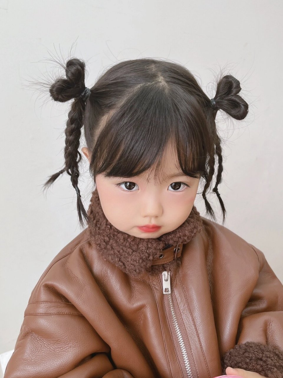 是爱心麻花辫女孩呀   阳光下,一位可爱的女孩梳着两个俏皮的爱心麻花