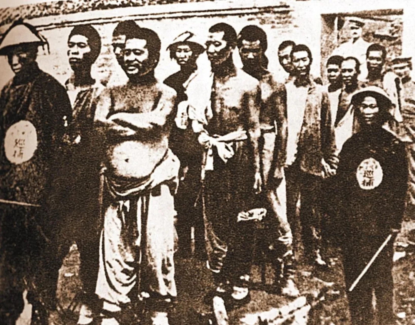 照片中,是十来个义和团拳民,他们被清兵和洋人抓住了.