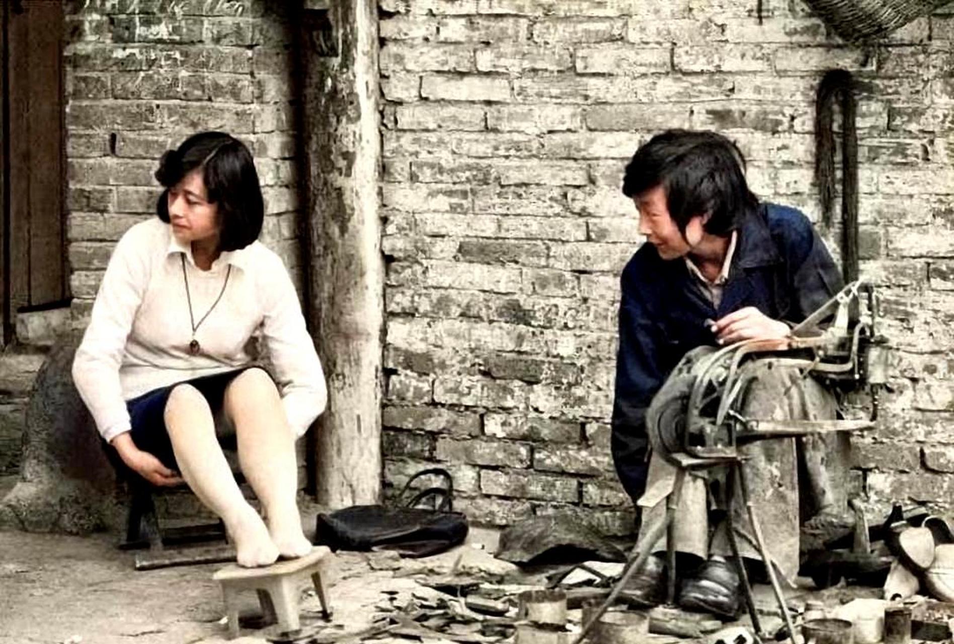 一张80年代的老照片,展现了一位修鞋匠正在修补鞋子.