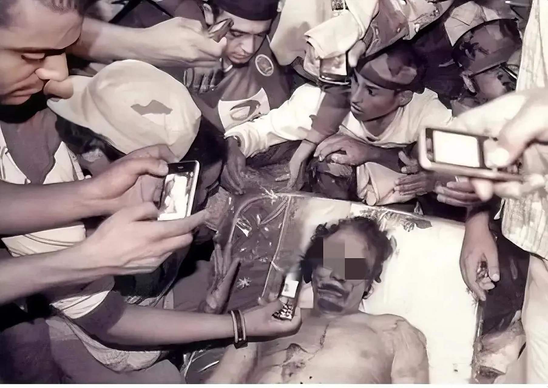 这是2011年,卡扎菲的遗体被放肉铺冷藏室供人参观时,留下的一张老照片