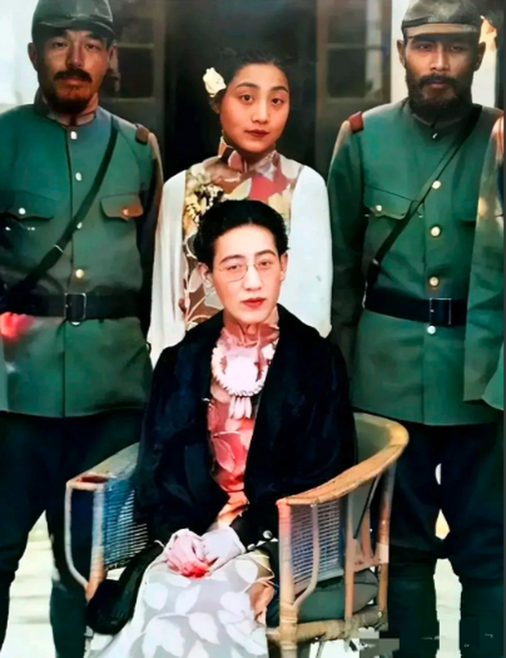 川岛芳子坐在第一排c位,在她身后就是她的侍女和日本军官,她长期被