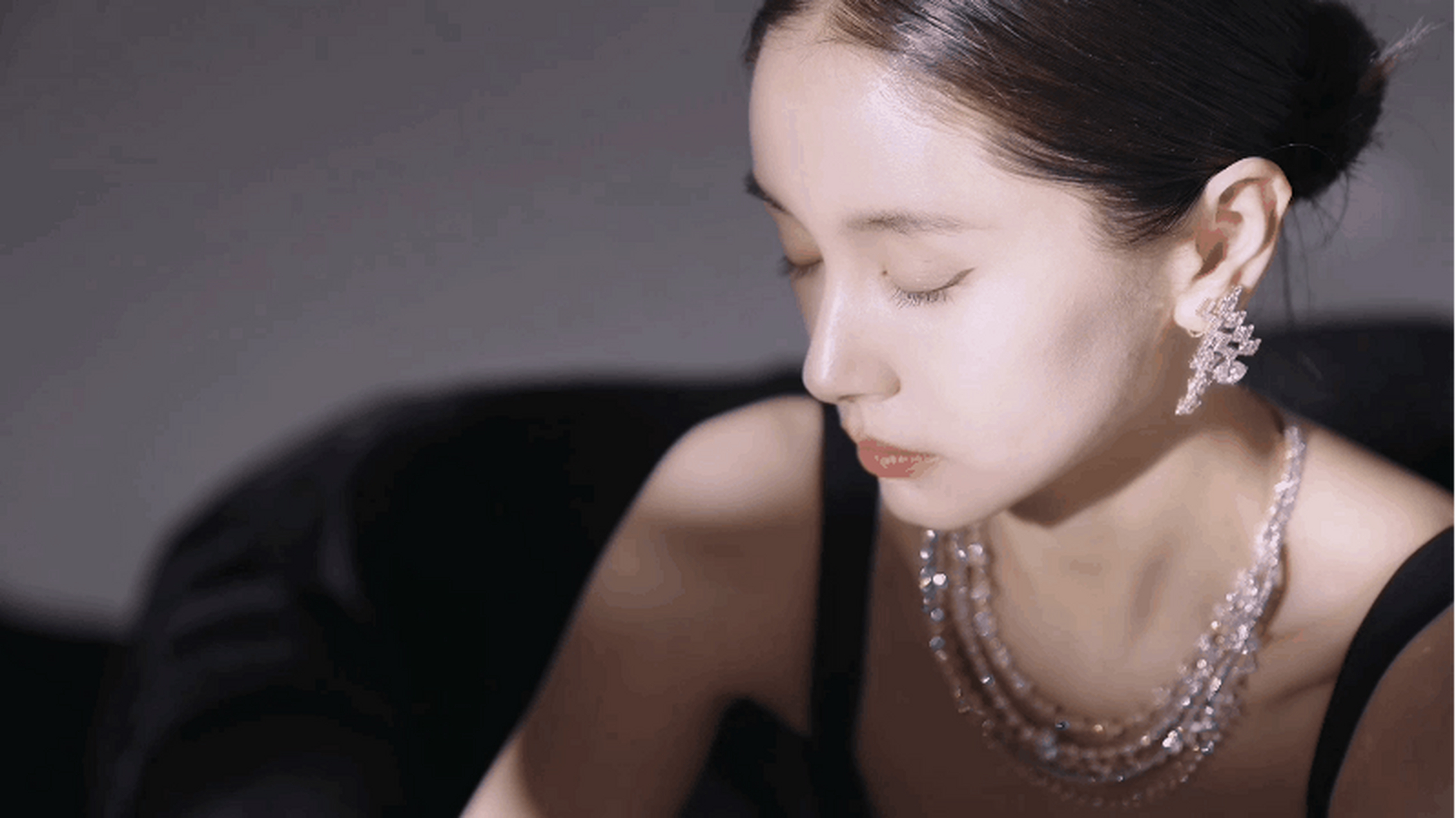 王子文光影黑天鹅氛围大片,黑色长裙搭配丸子头,钻石珠宝点缀,慵懒