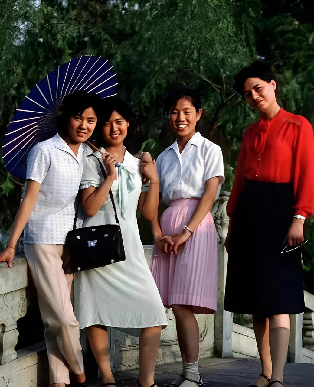 上世纪80年代上海的一张老照片中,几个穿着时尚的女孩打着油纸伞在