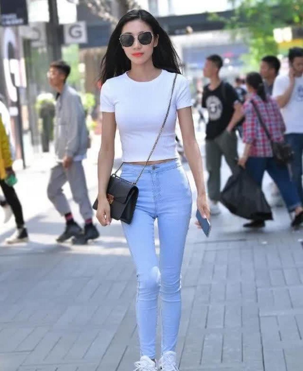 美女一件白色短袖t恤搭天蓝色修身牛仔裤,展现苗条而优美的身材
