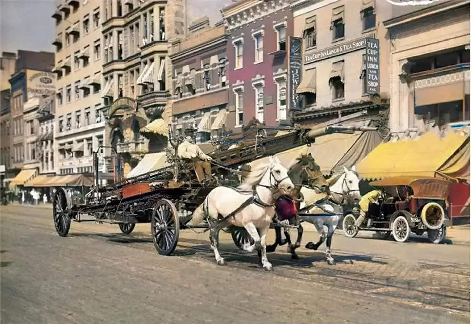 1914年的美国华盛顿街头,一辆三匹马拉着的消防车正奔驰在街道上,可以