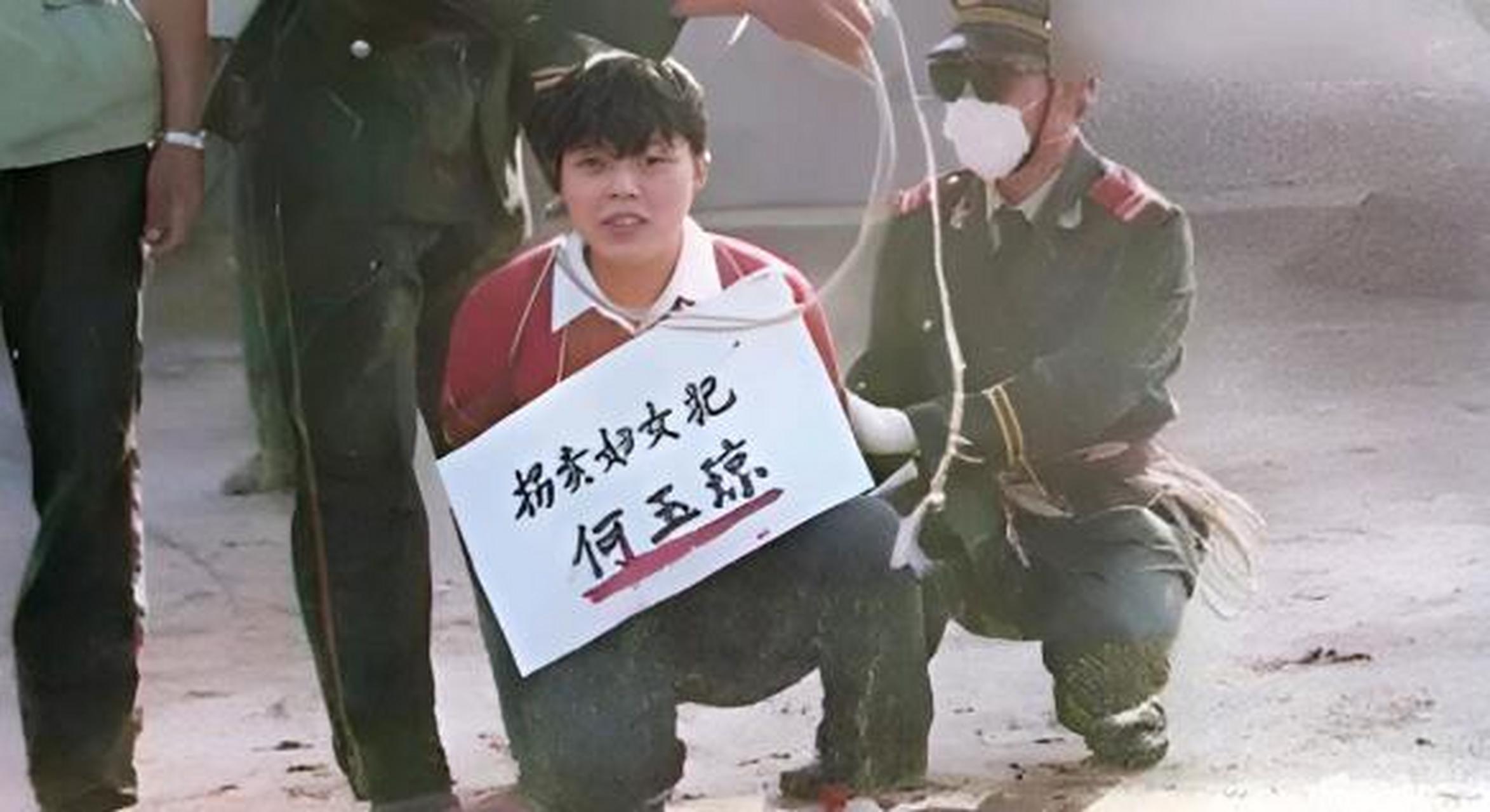 1995年,将被执行死刑的何玉琼半蹲在地上,一旁的法警正在给她捆绑"
