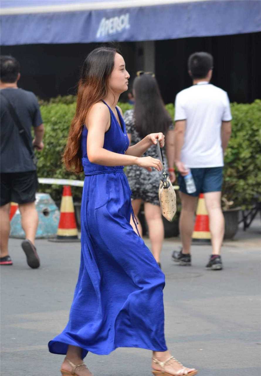 宝石蓝的连衣长裙,无袖款式设计,看起来非常简约,脚下一双坡跟鞋,也是