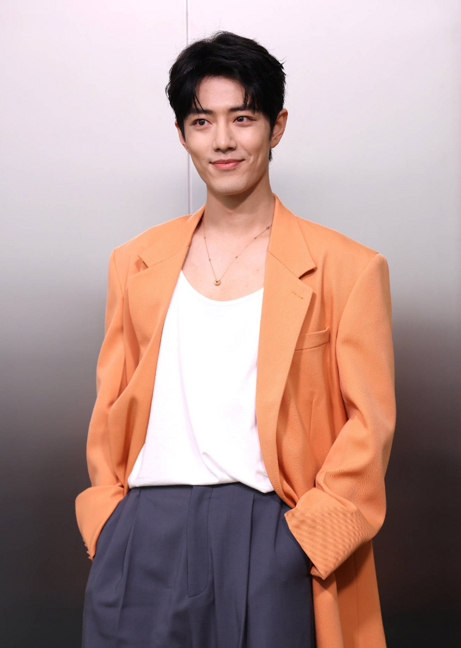 肖战米兰时装周看秀造型,橘色西装搭配白色背心,清新帅气.