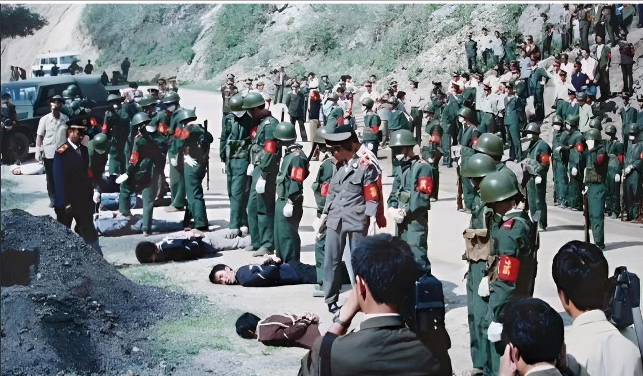 已经中弹倒地,法医正在仔细检查是否需要补枪,旁边除了拍摄现场的记者