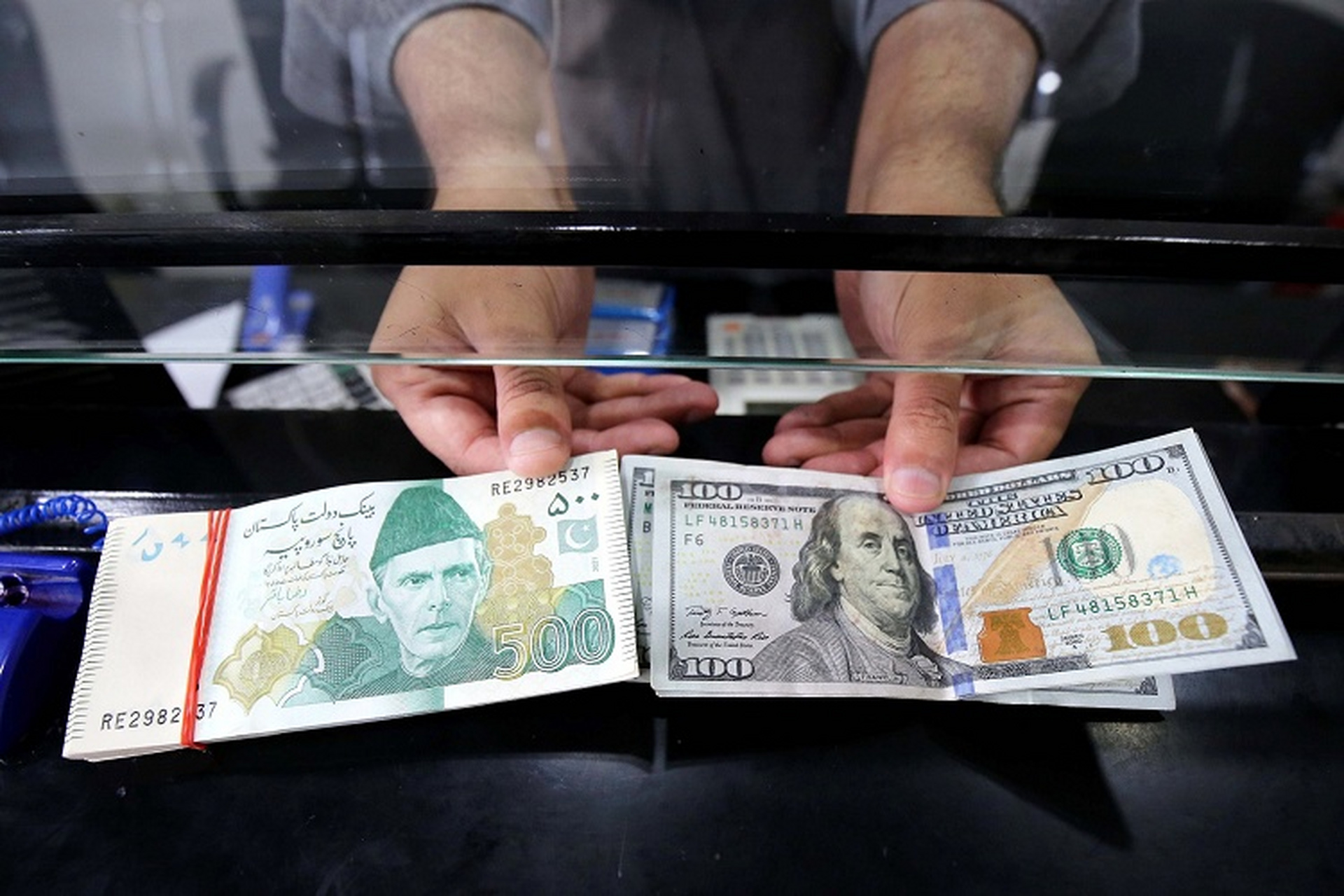 巴基斯坦卢比贬值危机 白沙瓦一家外币兑换店展示卢比和美元纸钞.