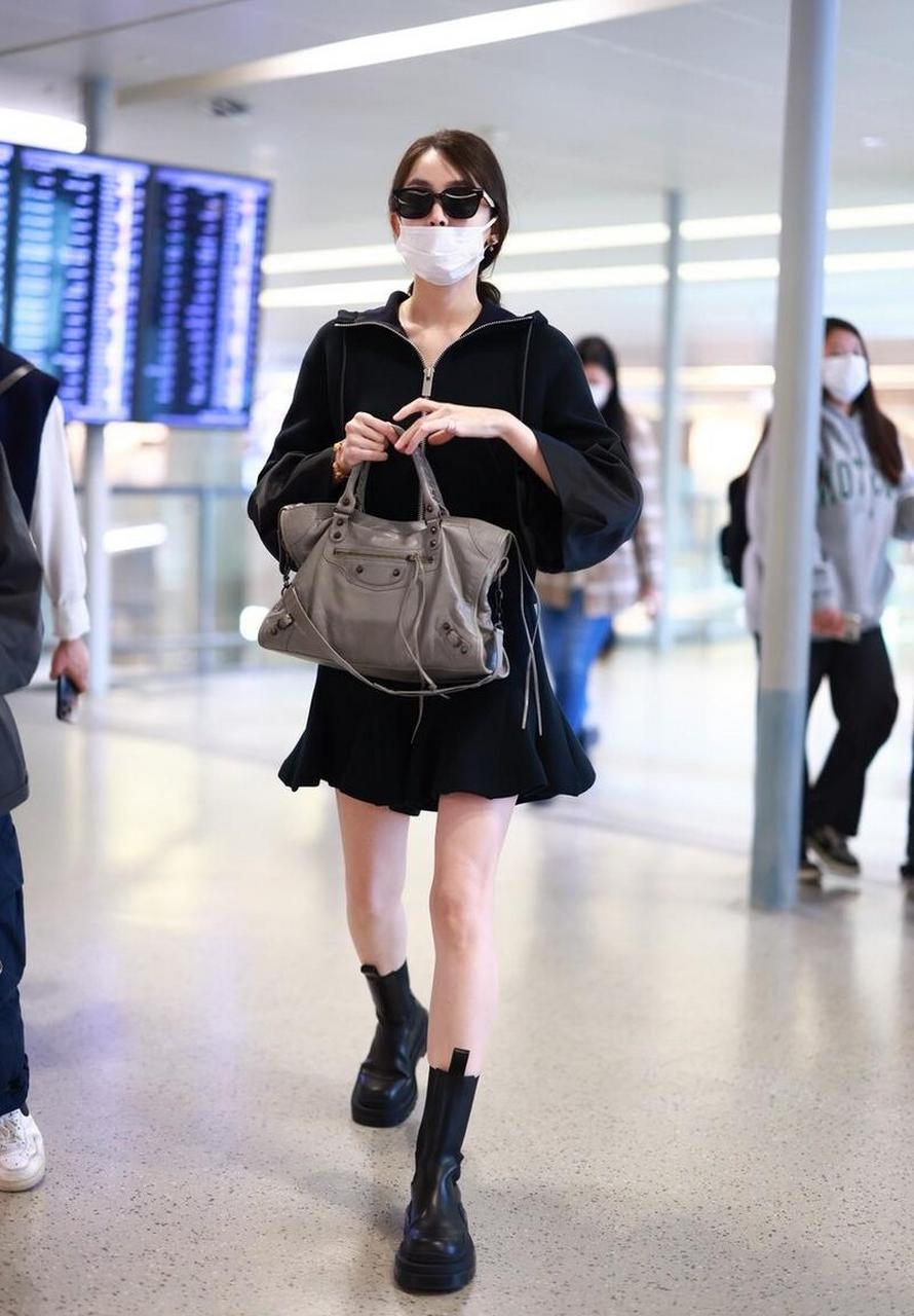 古力娜扎机场随拍,黑色连帽外套搭配半身短裙,切尔西靴甜酷可爱!