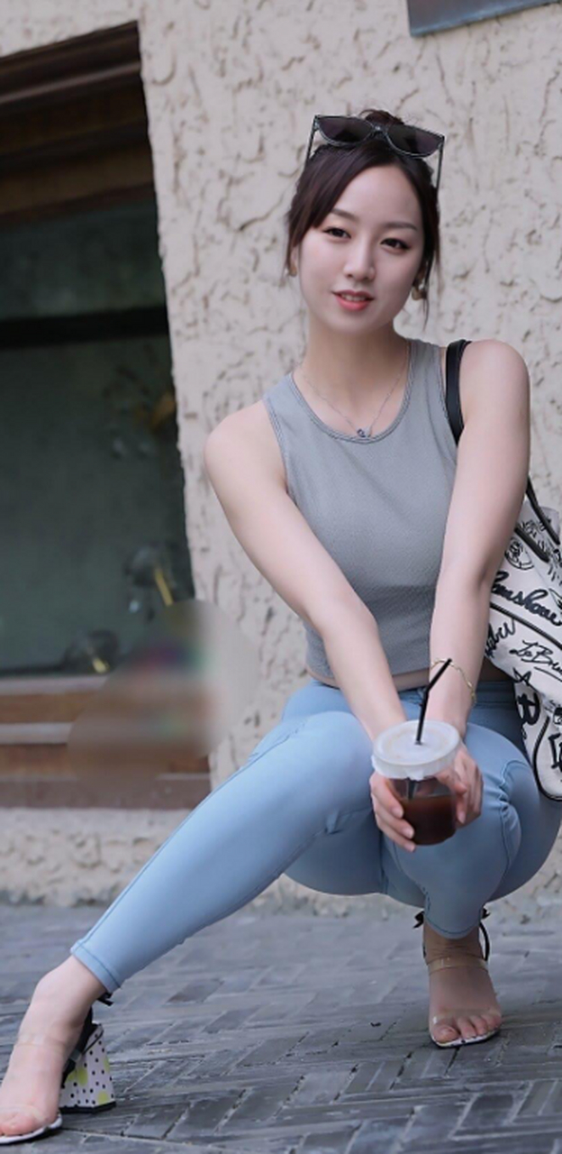 小姐姐身着修身牛仔裤搭配灰色小背心,身材凹凸有致尽显成熟女人魅力