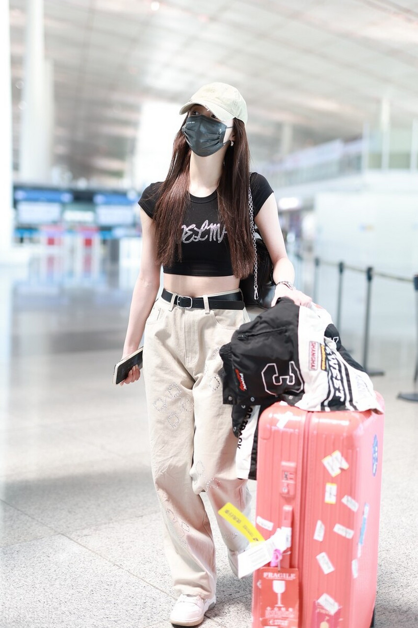 周洁琼机场街拍,黑色露脐t恤搭配卡其色阔腿裤,棒球帽潇洒活力!