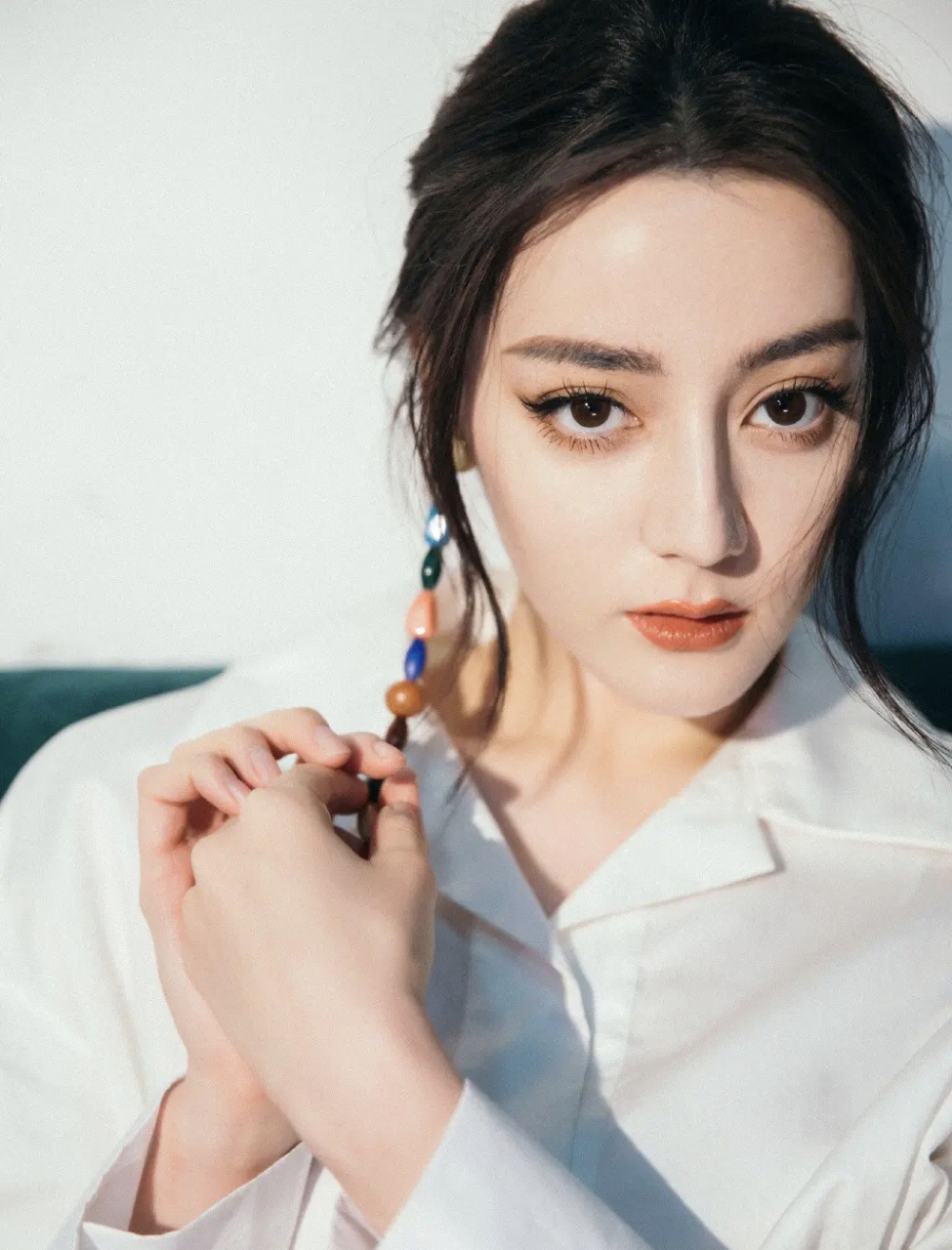 迪丽热巴的身材是真的好,穿白色修身服装戴单只彩色耳坠,整个人时尚