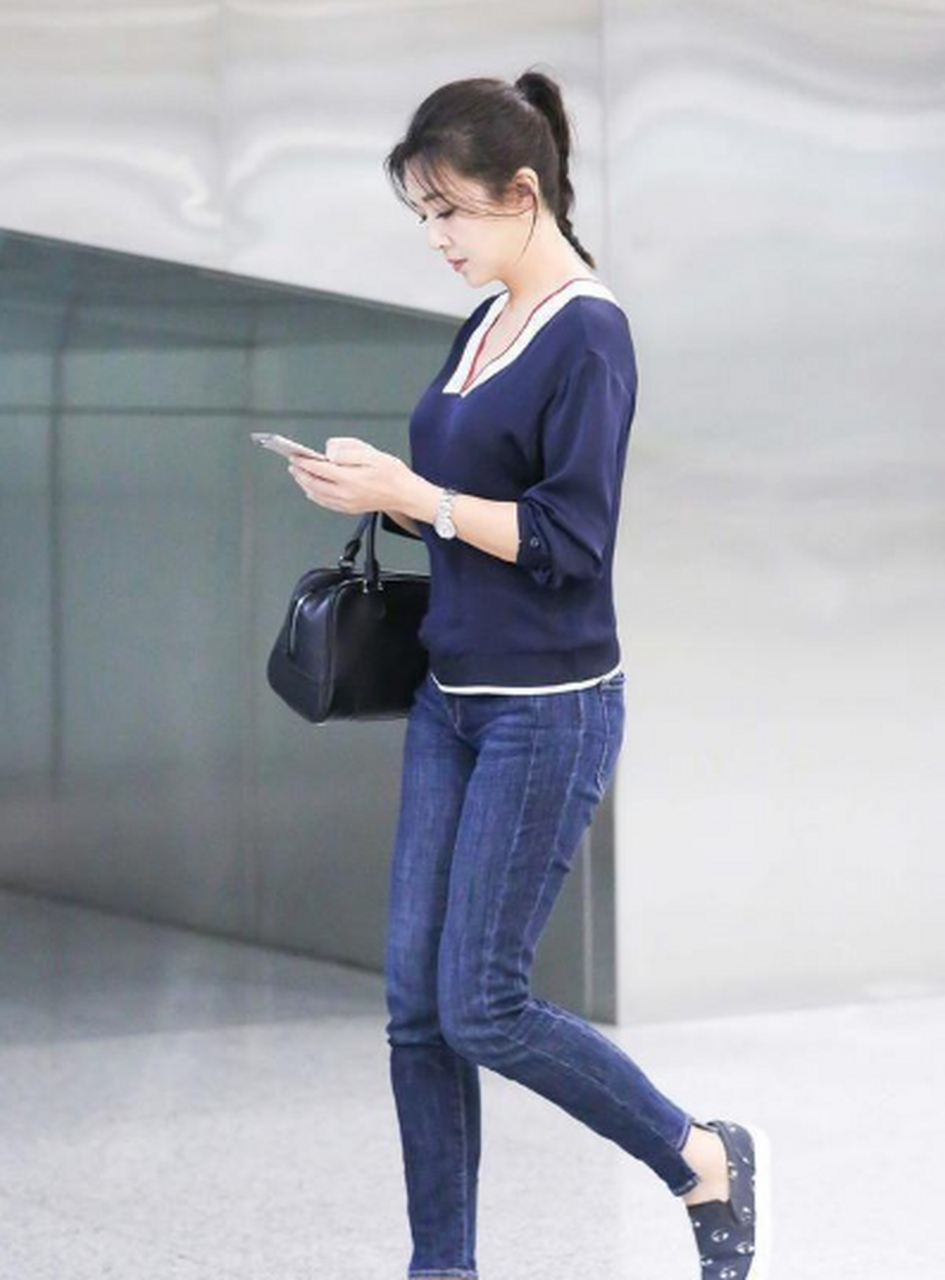 52岁的江珊罕见穿紧身牛仔裤,配v领针织衫现机场, 在某次机场出行时
